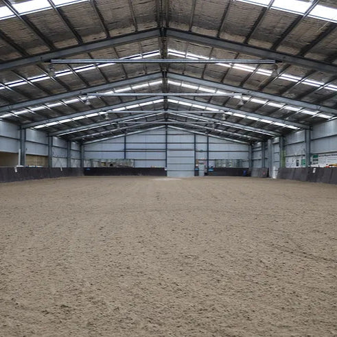 Large indoor equestrian arena with a sand silica base  and lights for night riding events.